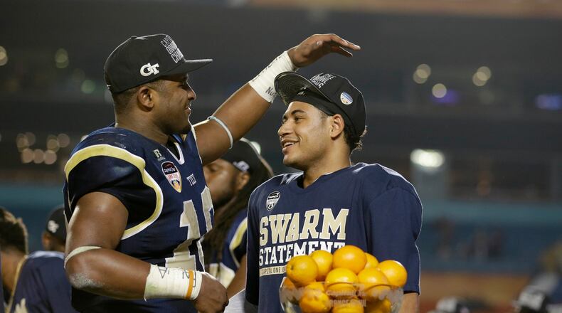 Georgia Tech quarterback Justin Thomas, right, is congratulated by running back Synjyn Days after Thomas was presented with the MVP trophy after Georgia Tech defeated Mississippi State 49-34 in the Orange Bowl NCAA college football game, Wednesday, Dec. 31, 2014, in Miami Gardens, Fla. (AP Photo/Wilfredo Lee)