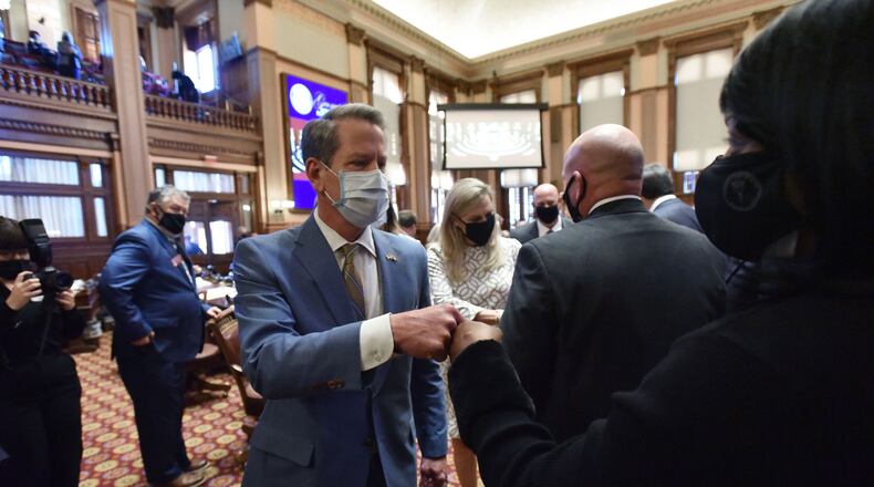 January 14, 2021 Atlanta - Gov. Brian Kemp exchanges fist-bumps with lawmakers as he leaves after he delivered the State of the State Address to lawmakers in the House Chambers during the 4th day of the 2021 legislative session at the Georgia State Capitol building on Thursday, January 14, 2021. (Hyosub Shin / Hyosub.Shin@ajc.com)