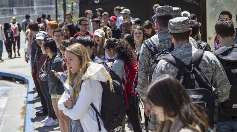 University of Georgia students wait for buses at the Tate Student Center bus stop on the University of Georgia campus in Athens, Georgia, on Tuesday, April 17, 2018. (REANN HUBER/REANN.HUBER@AJC.COM)