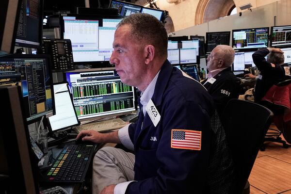 Trader Justin Flinn, left, works on the floor of the New York Stock Exchange, Friday, June 27, 2025. (AP Photo/Richard Drew)