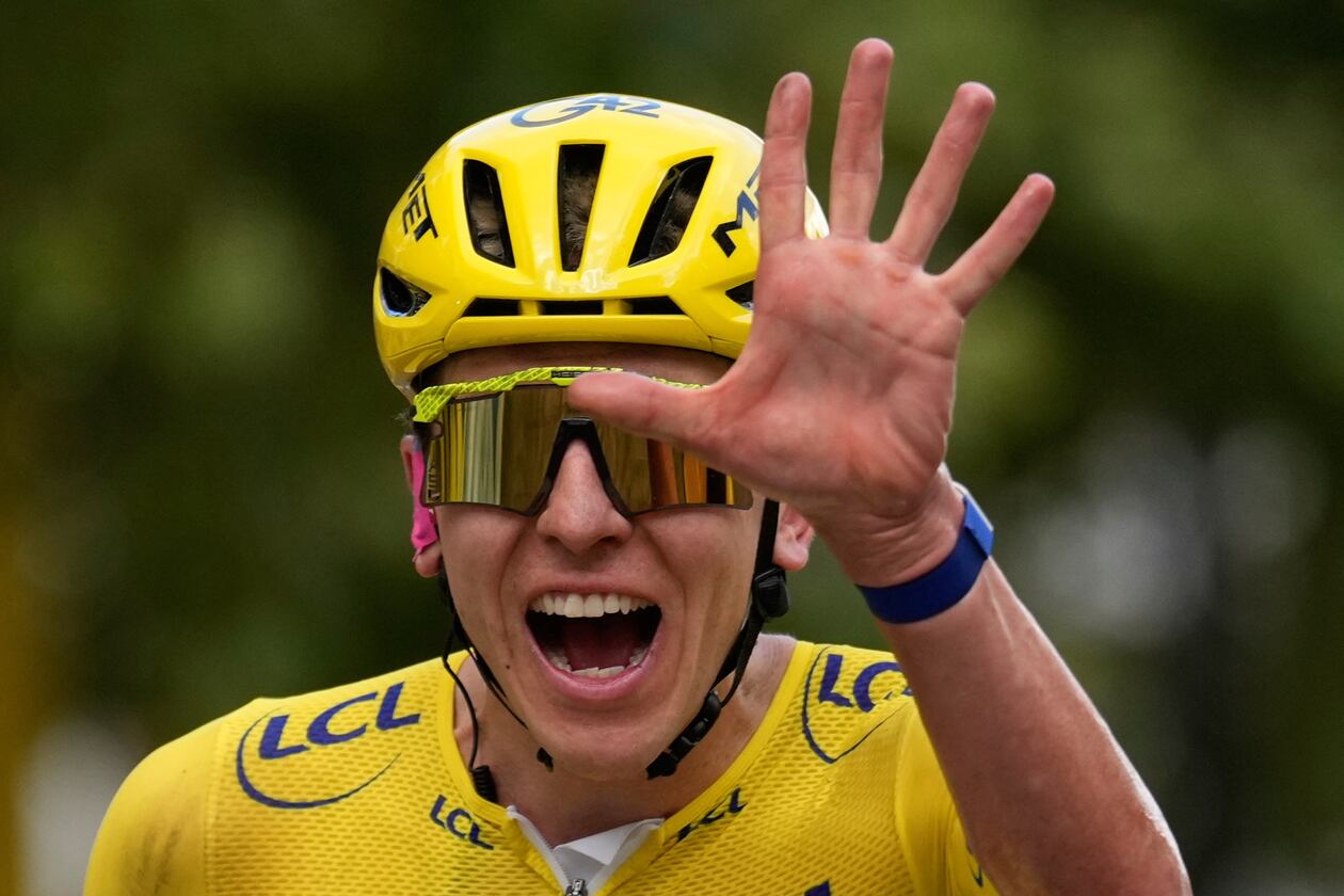 Slovenia's Tadej Pogacar, wearing the overall leader's yellow jersey, celebrates as he crosses the finish line of the last stage of the Tour de France cycling race with start and finish in Paris, Sunday, July 26, 2026. (AP Photo/Mosa'ab Elshamy)