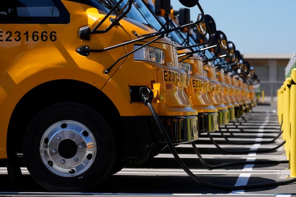 FILE - Zum electric buses are plugged into charging a station before a news conference announcing the Oakland Unified School District as being the first major school district in the country to use 100% electric school buses at the Zum/OUSD bus yard in Oakland, Calif., on Aug. 27, 2024. (AP Photo/Jeff Chiu, File)