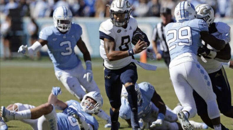 Georgia Tech's Tobias Oliver (8) runs the ball while North Carolina's J.K. Britt (29) misses the tackle during the first half of an NCAA college football game in Chapel Hill, N.C., Saturday, Nov. 3, 2018. (AP Photo/Gerry Broome)