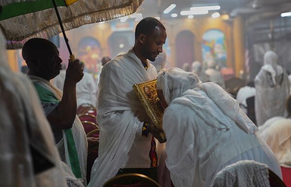 Worshippers kiss the holy Gospel during service at Re'ese Adbarat Debre Selam Kidist Mariam Church, an Ethiopian Orthodox Tewahedo church, in Washington, D.C., Saturday, April 5, 2025. (AP Photo/Jessie Wardarski)