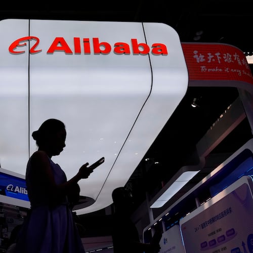 FILE - A visitor walks in front of Alibaba booth during the 3rd China International Supply Chain Expo at the China International Exhibition Center, in Beijing, China, Friday, July 18, 2025. (AP Photo/Mahesh Kumar A., file)