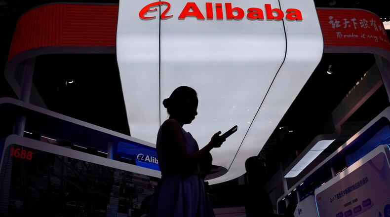 FILE - A visitor walks in front of Alibaba booth during the 3rd China International Supply Chain Expo at the China International Exhibition Center, in Beijing, China, Friday, July 18, 2025. (AP Photo/Mahesh Kumar A., file)