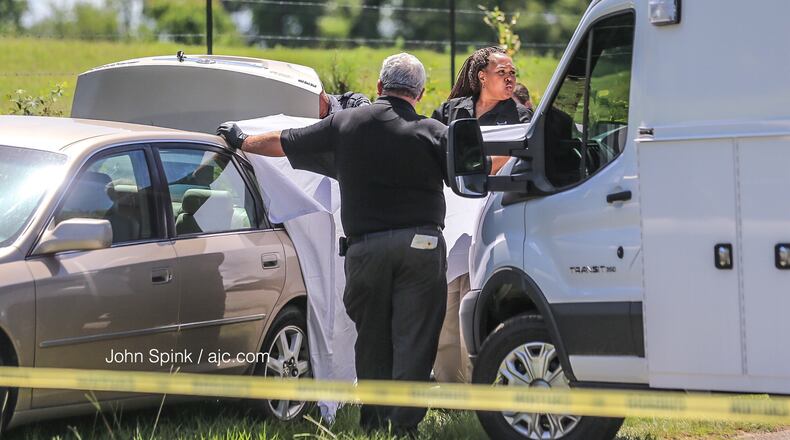 Barrow County Sheriff investigators at Whitley Road and Kilcrease Drive examine a car where a body was found in the trunk.