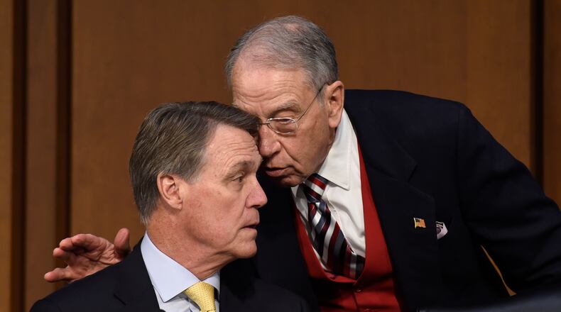 Senate Judiciary Committee Chairman Sen. Charles Grassley, R-Iowa, right, talks with Sen. David Perdue, R-Ga., as Attorney General nominee Loretta Lynch testifies on Capitol Hill in Washington, Wednesday, Jan. 28, 2015, before the committees hearing on her nomination. If confirmed, Lynch would replace Attorney General Eric Holder, who announced his resignation in September after leading the Justice Department for six years. The 55-year-old federal prosecutor would be the nations first black female attorney general. (AP Photo/Susan Walsh)
