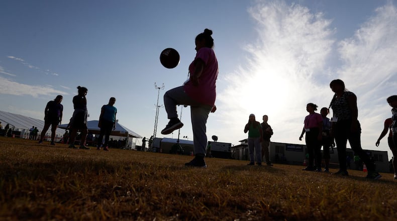 In this July 9, 2019, photo, immigrants play soccer at the U.S. government's newest holding center for migrant children in Carrizo Springs, Texas.