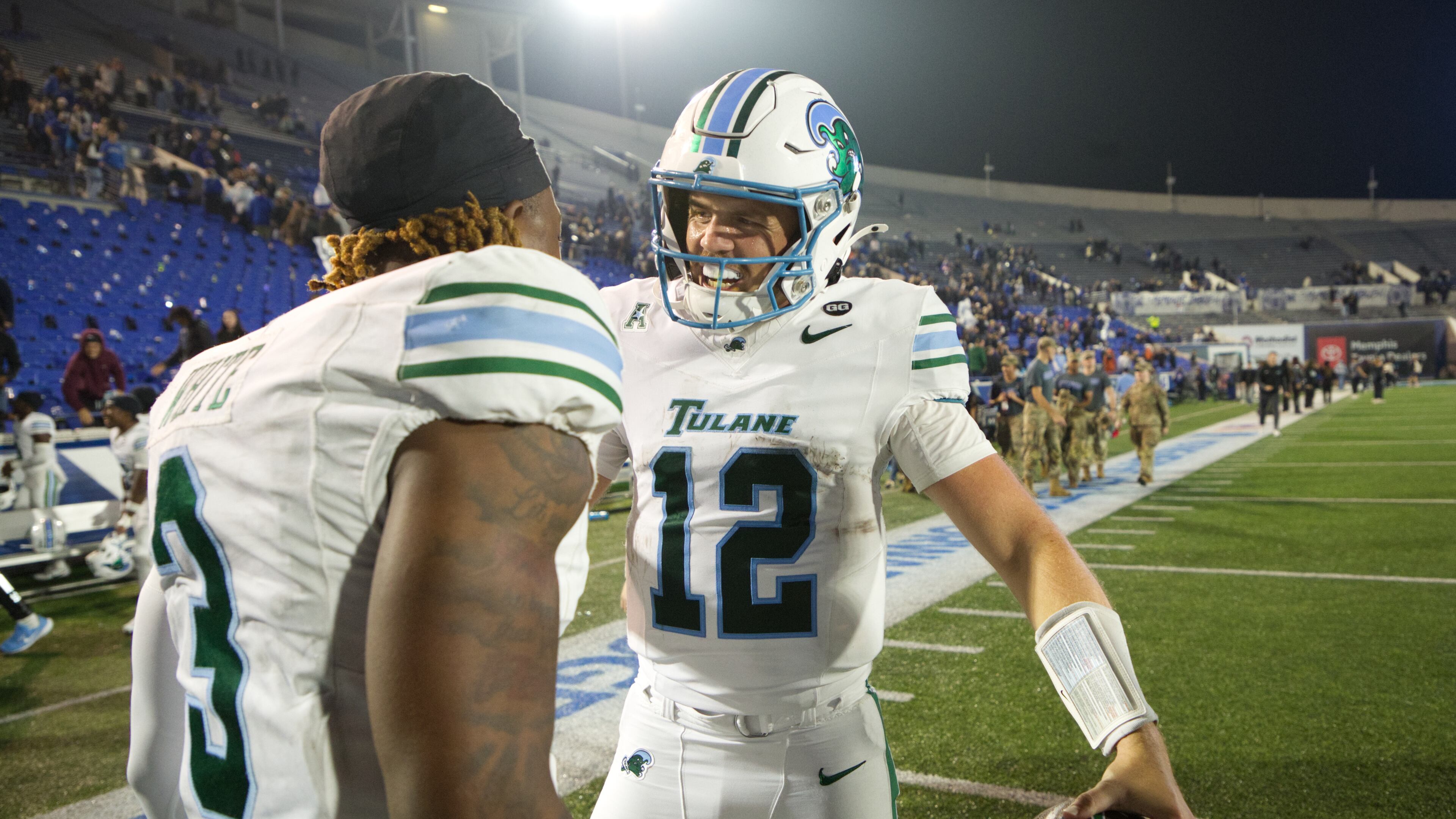 Tulane quarterback Jake Retzlaff (12) celebrates with Tulane defensive back Javion White (3) after defeating Memphis in an NCAA college football game, Friday, Nov. 7, 2025, in Memphis, Tenn. (AP Photo/Nikki Boertman)