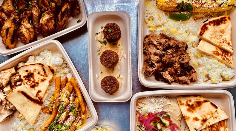 This takeout meal from Local Expedition includes (clockwise from upper left) chicken wings; falafel; pulled pork with Mexican corn; hummus; a side of potato salad; and smoked chicken with a side of “local” fries (topped with cilantro and lemon-garlic sauce, cotija cheese, parsley, and sumac). Plates come with rice and pita. Wendell Brock for The Atlanta Journal-Constitution