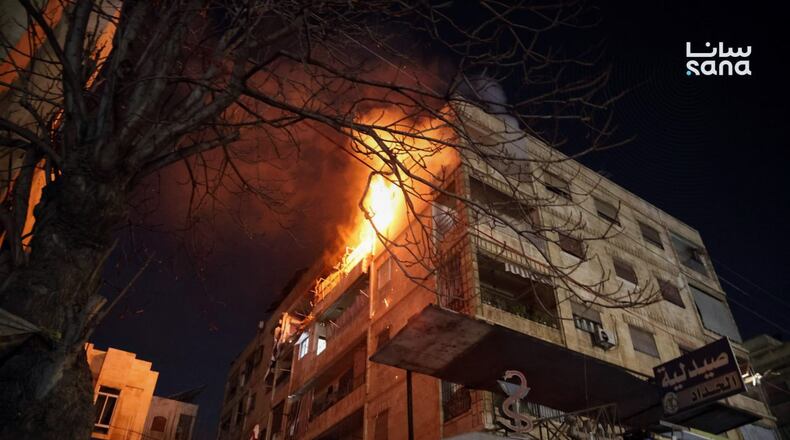 This photo released by the official Syrian news agency SANA, shows flames rising from a building after clashes broke out between security forces and Kurdish fighters in neighborhoods of the northern Syrian city of Aleppo, Syria, Monday, Dec. 22, 2025. (SANA via AP)