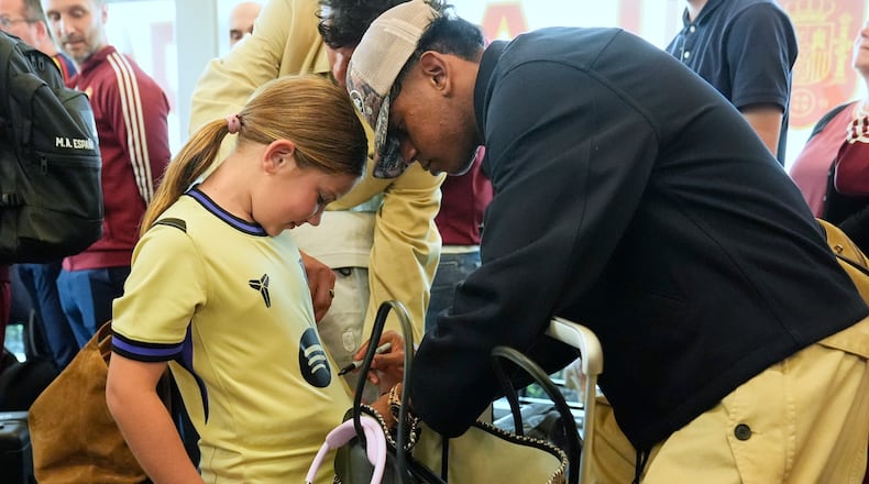 Spain midfielder Lamine Yamal, right, signs an autograph for Griffin Wamp, left, after arriving with teammates for the World Cup soccer tournament Friday, June 5, 2026, in Chattanooga, Tenn. (AP Photo/George Walker IV)