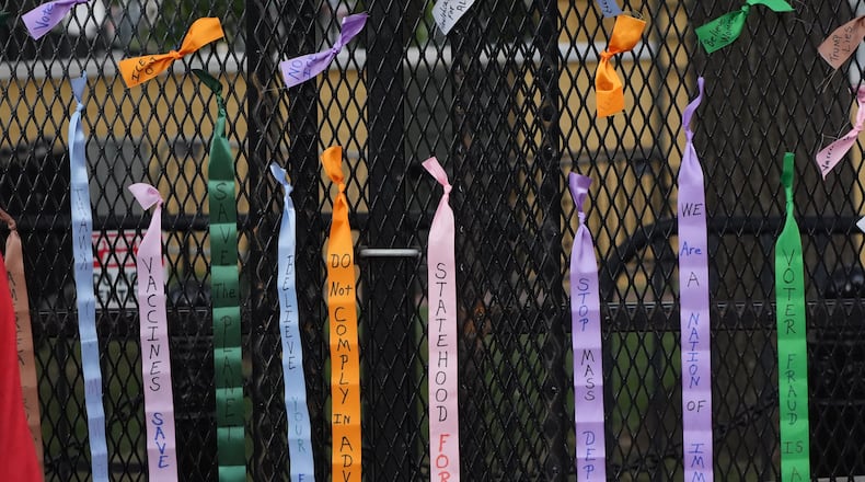 Protest ribbons are tied to a fence at Lafayette Park, near the White House, Tuesday, Aug. 25, 2026, in Washington. (AP Photo/Alex Brandon)