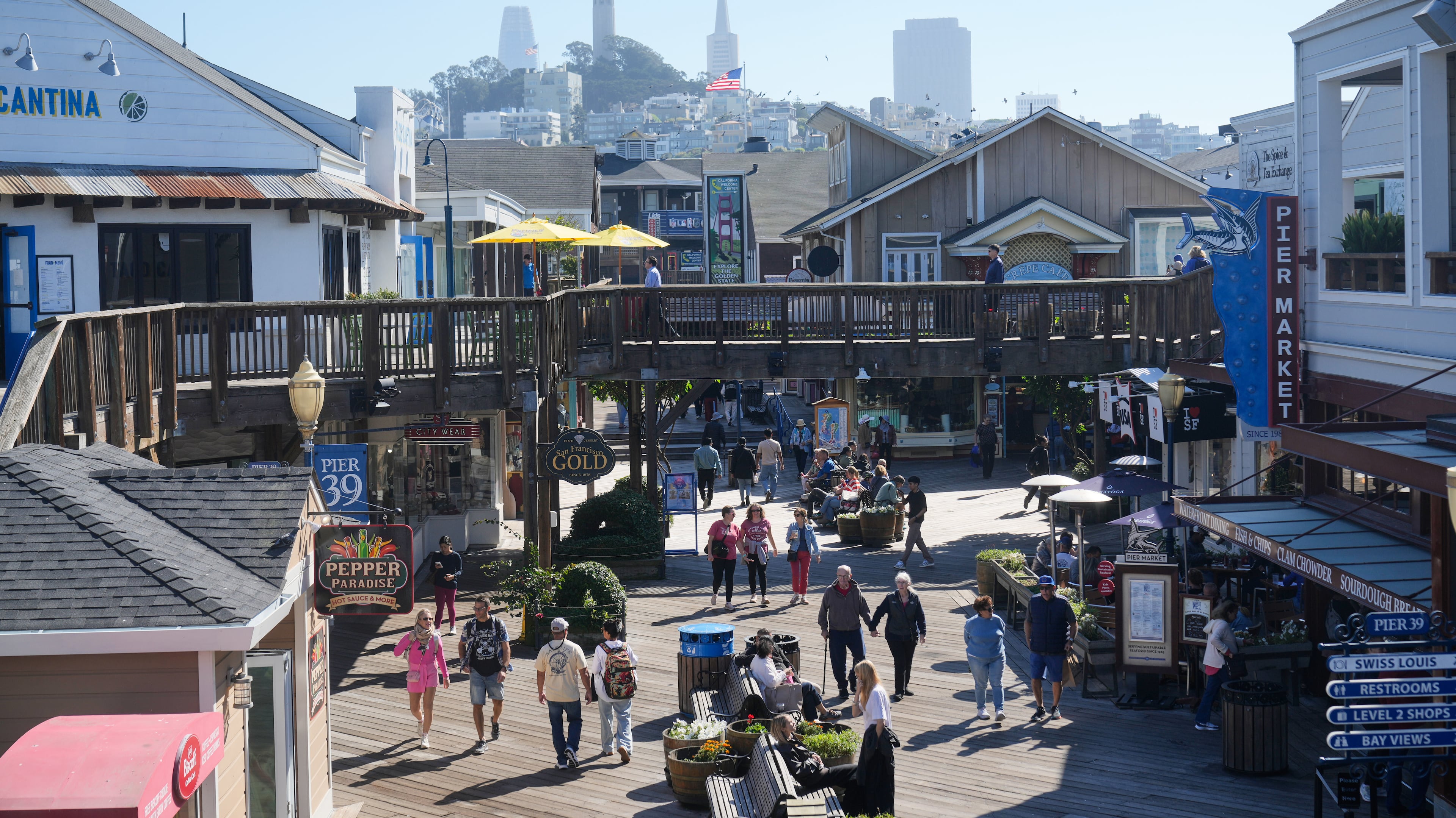 Visitors walk on the boardwalk at Fisherman's Wharf on Tuesday, Oct. 21, 2025, in San Francisco. (AP Photo/Jeff Chiu)