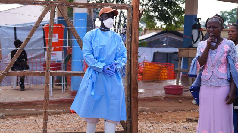 Residence watch as health workers carry a coffin of an Ebola victim at Ebola Treatment Center at Bunia General Hospital in Ituri, Congo, Wednesday, July 22, 2026. (AP Photo/Dirole Lotsima Dieudonne)