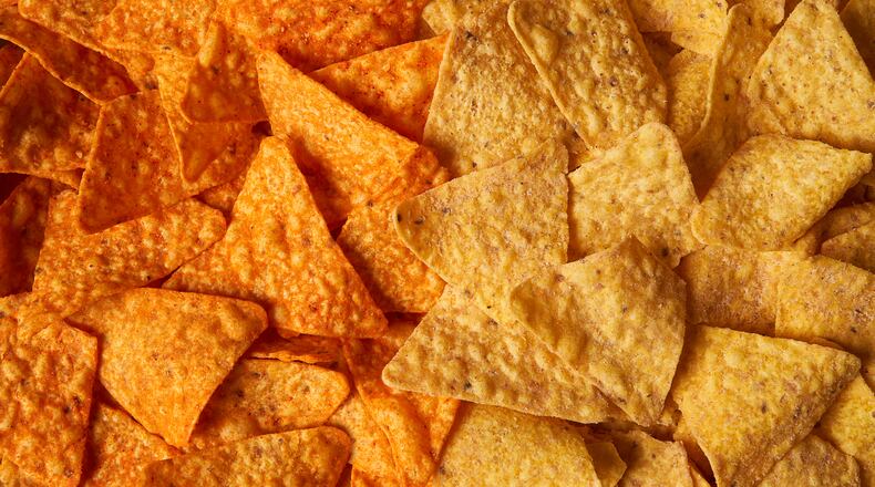 This image provided by PepsiCo shows from left, shows original Doritos Nacho cheese chips next to new Doritos without artificial colors or flavors. (PepsiCo via AP)