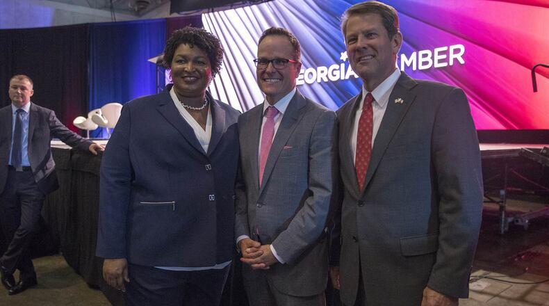 Georgia gubernatorial candidates Stacey Abrams and Brian Kemp, right, stand Tuesday with Georgia Chamber of Commerce President and CEO Chris Clark following the group’s Congressional Luncheon at the Macon Marriott City Center. Both candidates used the forum to explain their plans for Georgia’s economy. (ALYSSA POINTER/ALYSSA.POINTER@AJC.COM)
