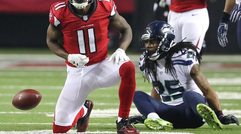 Falcons wide receiver Julio Jones makes a first down catch against Seahawks cornerback Richard Sherman during the third quarter in a NFL football NFC divisional playoff game on Saturday. Curtis Compton/ccompton@ajc.com