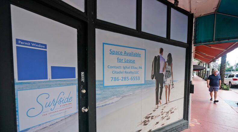 A pedestrian walks past an empty business available for lease, Monday, Oct. 12, 2020, in downtown Surfside, Fla. (AP Photo/Wilfredo Lee)