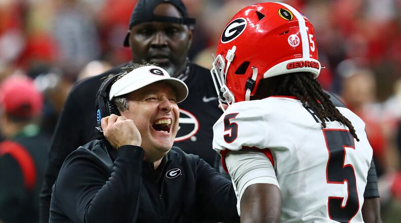 Georgia head coach Kirby Smart reacts with defensive back Kelee Ringo after he intercepted a Alabama quarterback Bryce Young pass and returner it for a touchdown for a 33-18 lead and the victory over Alabama during the 4th quarter in the College Football Playoff Championship game on Monday, Jan. 10, 2022, in Indianapolis.  Curtis Compton / Curtis.Compton@ajc.com