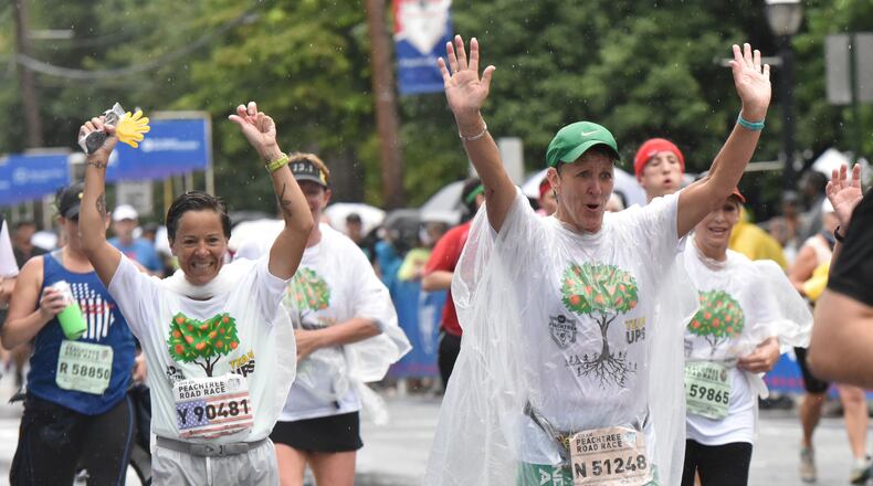 Lot of waving going on during last year’s AJC Peachtree Road Race on Saturday, held on July 4, 2015. HYOSUB SHIN / HSHIN@AJC.COM