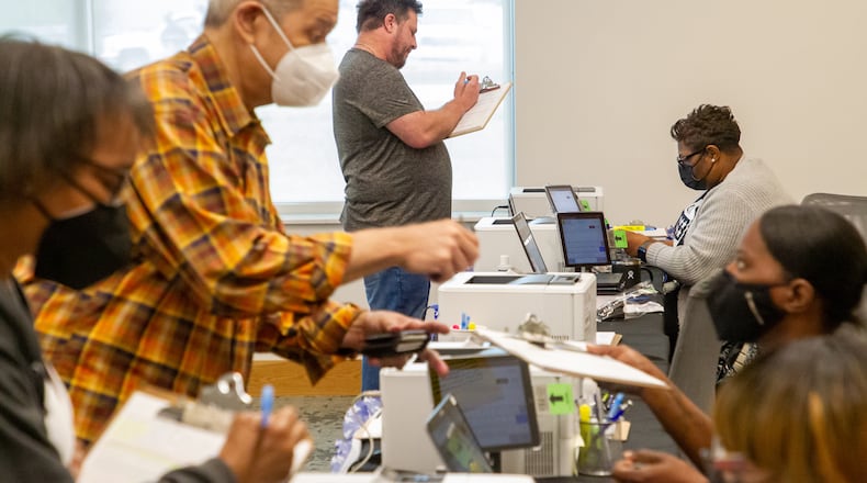 People fill out their paperwork at the Metropolitan Library in Atlanta on the last Saturday of early voting, May 14, 2022. (Steve Schaefer / steve.schaefer@ajc.com)