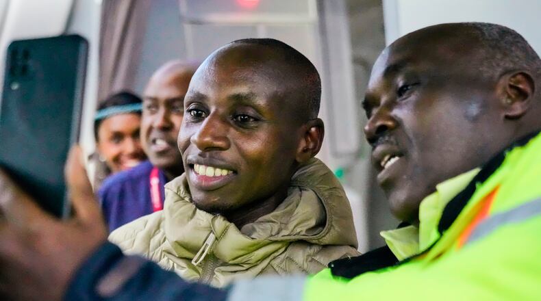 Sabastian Sawe poses for a selfie with an airport worker after arriving on a plane from London, Wednesday, April 29, 2026, at Jomo Kenyatta International Airport in Nairobi, Kenya, after setting a new world record in the marathon. (AP Photo/Brian Inganga) CORRECTION: Corrects spelling of first name to Sabastian, not Sebastian