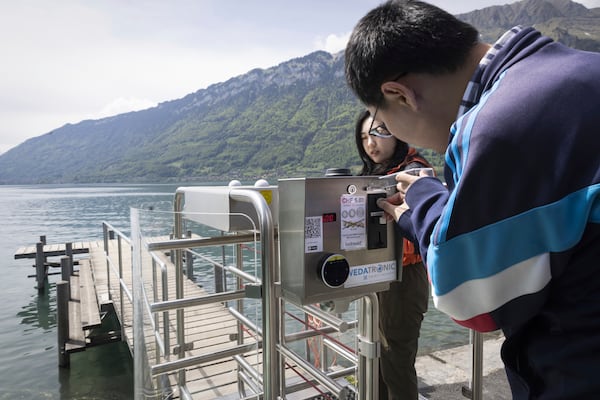 Korean visitors pay 5 Swiss Francs to get on the pier at Lake Brienz in Iseltwald, Switzerland, Sunday, May 21, 2023. (Peter Klaunzer/Keystone via AP)
