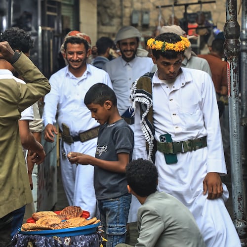 People walk past a boy selling bread at a street market in Sanaa, Yemen, Saturday, Aug. 8, 2026. (AP Photo/Osamah Abdulrahman)