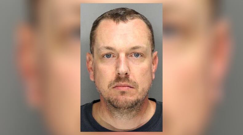 Daniel Ryan Caudell, 45, was arrested Friday after he was seen with a gun, knife and alcohol on the Sprayberry High School campus, according to police.