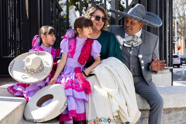 From left: Daniela, 7, Denisse, 6, Monica and Mauricio Echeveste, part of equestrian group Union Charreria Associations of Georgia and Tennessee, sit outside the state Capitol on Wednesday.