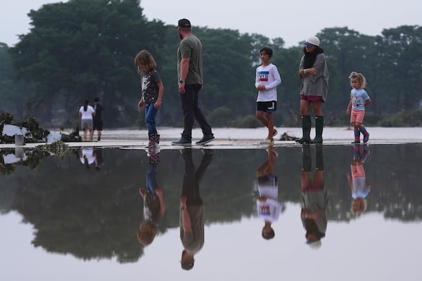 Onlookers survey damage along the Guadalupe River after a flash flood swept through the area, Friday, July 4, 2025, in Kerrville, Texas. (AP Photo/Eric Gay)