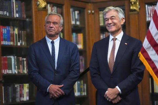 U.S. Health and Human Services Secretary Robert F. Kennedy, Jr., left, and Centers for Medicare and Medicaid Services Administrator Dr. Mehmet Oz listen during a Make Indiana Healthy Again initiative event in Indianapolis, Tuesday, April 15, 2025. (AP Photo/Michael Conroy)