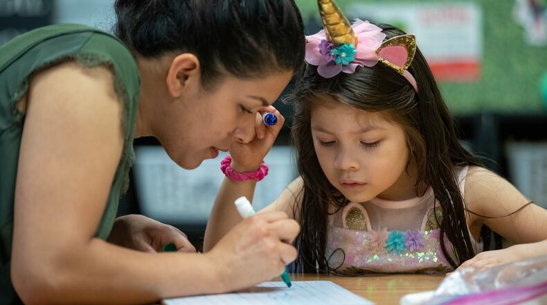 Josselyn Larin helps her daughter Grace with one of her lessons at B.B. Harris Elementary School in Duluth May 13, 2022. Gwinnett County Public Schools is hosting online programs meant to help parents learn about supporting language arts and math lessons at home. (Steve Schaefer / steve.schaefer@ajc.com)