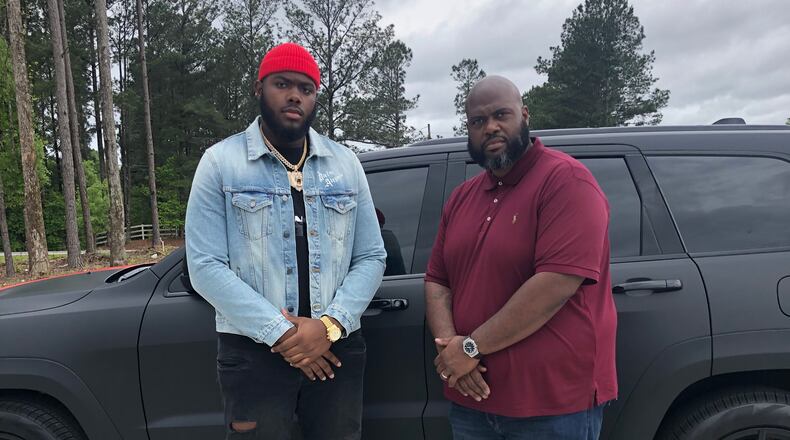 Georgia offensive tackle Andrew Thomas (L) poses with Kevin Johnson, his position coach at Pace Academy, in the driveway of Johnson's Fayetteville home Thursday. There, pupil and coach were taking in the first round of the NFL draft. (Special photo)