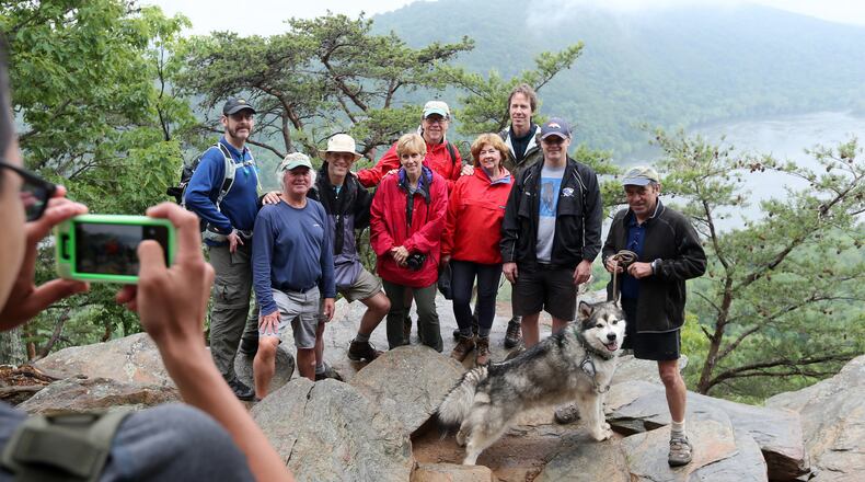 May 21, 2015, Harpers Ferry, WV: The Appalachian Adventure reunion crew enlists a hiker to help with a group photo at Weverton Cliff above Harpers Ferry, WV. Pictured are Chris Hunt, from left, Steve Grant, Scott Huler, Robin Rombach, Don Hopey, Martha Ezzard, Bo Emerson, John Ezzard and Walter Cumming with his dog Tanook. Ben Gray / bgray@ajc.com