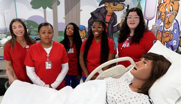 Columbus State University nursing students gather around “Victoria,” the mannequin mom that’s part of the new mother-baby simulation lab at CSU’s School of Nursing. (Photo Courtesy of Mike Haskey)