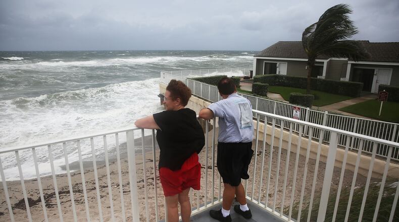 JUPITER, FL - OCTOBER 06: Karen Lanman and Don Lanman look out at the churning ocean as Hurricane Matthew approaches the area on October 6, 2016 in Jupiter, Florida. The hurricane is expected to make landfall sometime this evening or early in the morning as a possible category 4 storm. (Photo by Joe Raedle/Getty Images)