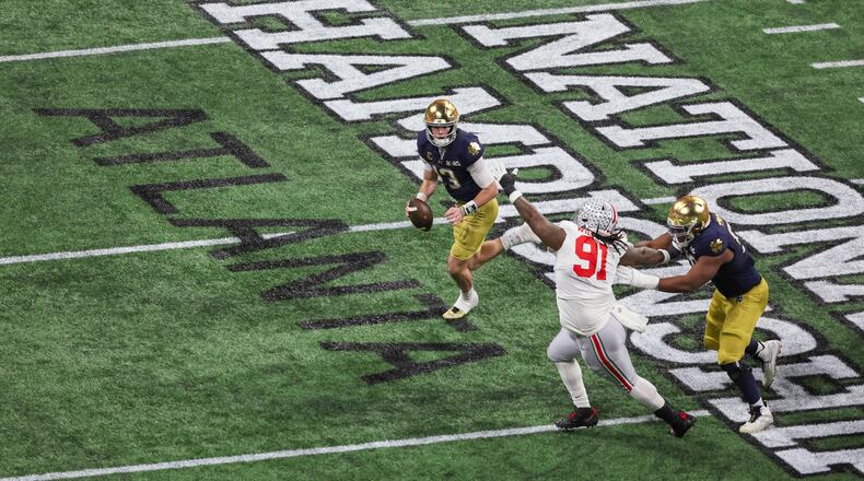 Notre Dame quarterback Riley Leonard (13) runs against Ohio State defensive tackle Tyleik Williams (91) during the first half of the 2025 National Championship at Mercedes-Benz Stadium, Monday, Jan. 20, 2025, in Atlanta. (Jason Getz/AJC)