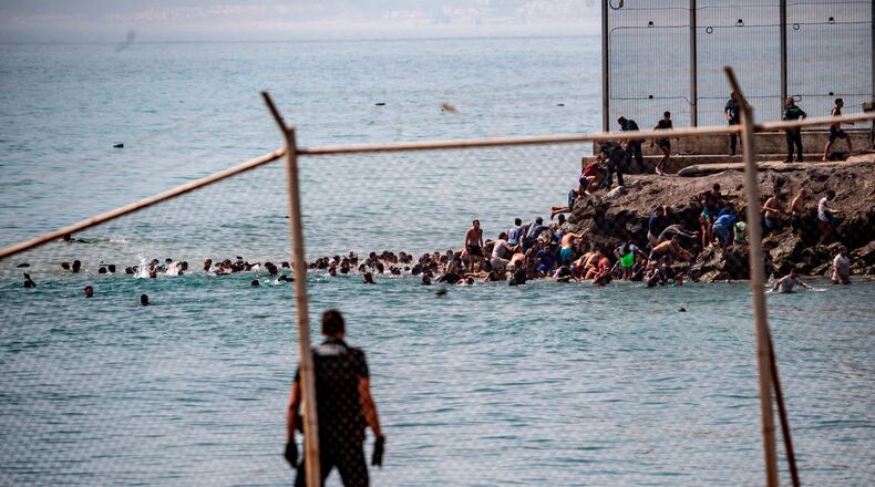 Migrants cross from Morocco into the Spanish enclave of Ceuta, Thursday, July 30, 2026. (AP Photo/Antonio Sempere)