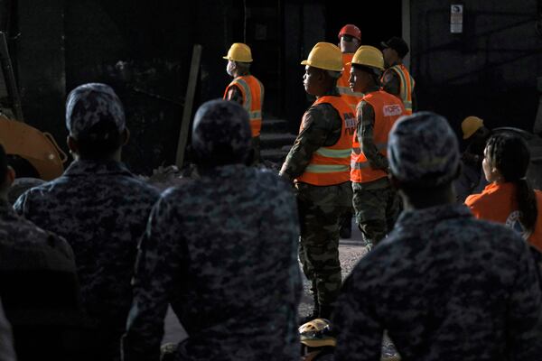 Rescue workers stand by as they take turns searching for survivors at the Jet Set nightclub after its roof collapsed two nights ago during a merengue concert in Santo Domingo, Dominican Republic, Wednesday, April 9, 2025. (AP Photo/Ricardo Hernandez)