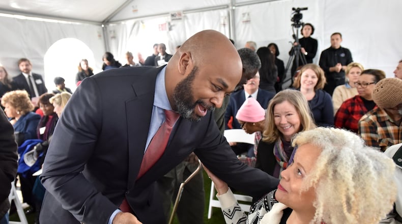 December 15, 2016 Atlanta - Atlanta City Councilman Kwanza Hall (left) greets Lynne Alston-Leonard (right) before the grand opening of the City of Lights, a new affordable senior housing facility in Old Fourth Ward on Thursday. HYOSUB SHIN / HSHIN@AJC.COM