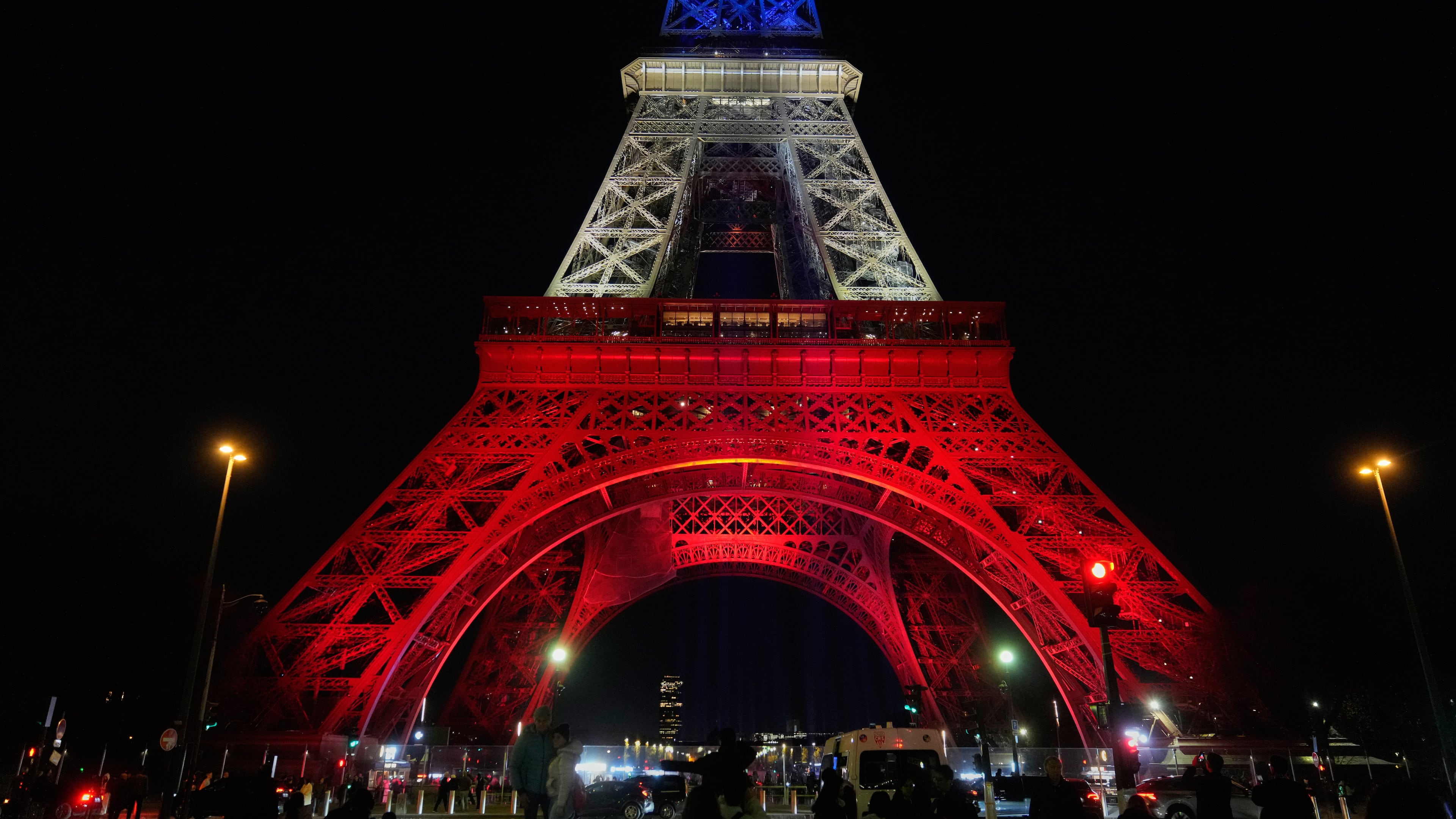 The Eiffel Tower is lit in the colors of the French national flag in Paris, Wednesday, Nov. 12, 2025, to honor the victims of the terror attacks at the Bataclan concert hall, cafes, and the national stadium 10 years ago. (AP Photo/Michel Euler)