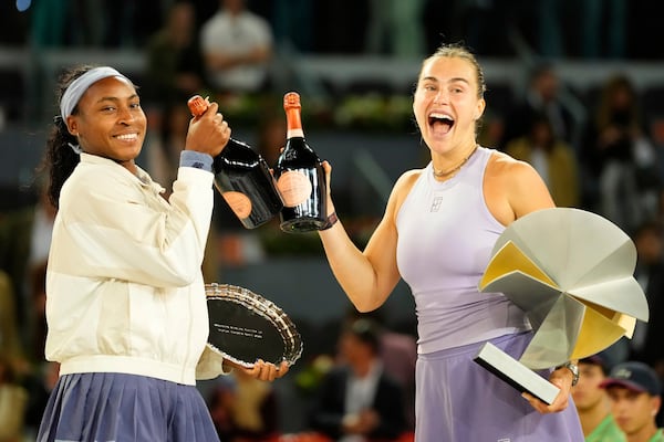 United States' Coco Gauff, left, and the winner Aryna Sabalenka of Belarus stand on the podium after the Madrid Open tennis final in Madrid, Spain, Saturday, May 3, 2025. (AP Photo/Jose Breton)