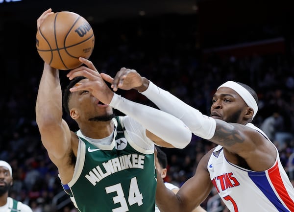 Milwaukee Bucks forward Giannis Antetokounmpo (34) is fouled by Detroit Pistons forward Paul Reed (7) while trying to take a shot during the first half of an NBA basketball game Friday, April 11, 2025, in Detroit. (AP Photo/Duane Burleson)
