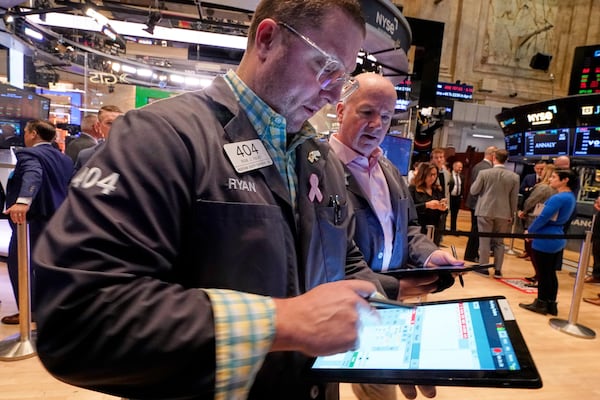Traders Ryan Falvey, left, and Patrick Casey work on the floor of the New York Stock Exchange, Thursday, April 10, 2025. (AP Photo/Richard Drew)