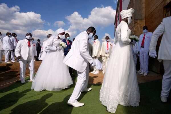 Couples dance as they enter the church building during a mass Easter weddings for 3,000 people, some polygamous, at the International Pentecost Holiness Church, in Heidelberg, east of Johannesburg, South Africa, Sunday, April 20, 2025. (AP Photo/Themba Hadebe)