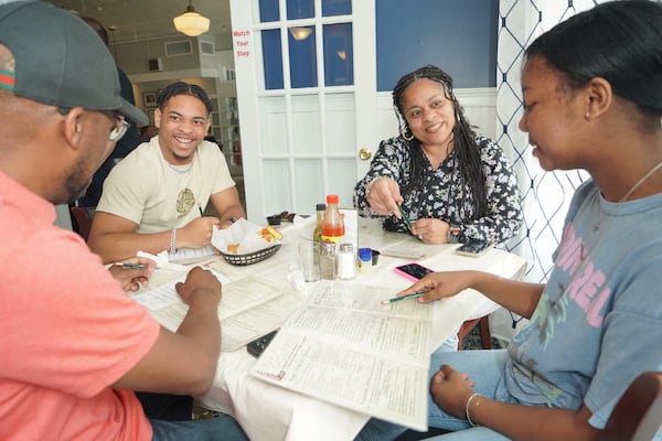 A group of four people surround a table at Mary Mac's Tea Room