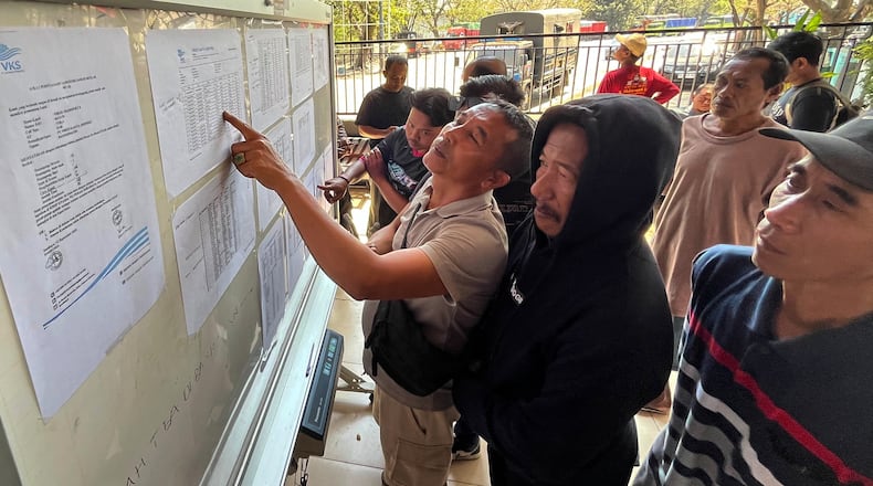 People check the passenger manifest of Virgo Transport 8 passenger ferry which overturned in bad weather in the Java Sea, at the rescuers' command center in Banjarmasin, South Kalimantan, Indonesia, Monday, Sept. 14, 2026. (AP Photo/Iman Satria)